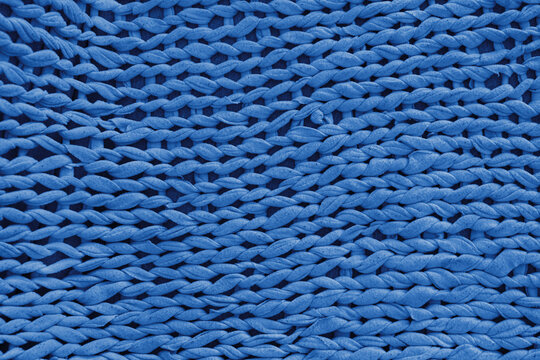 Macro, close up, detailed blue knitted textile, fabric texture with chunky yarn pattern suface. Cozy handmade cloth background, knitwear backdrop , perfect for design, crafts, warm winter concept