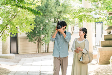 A man and woman taking photos with a single-lens reflex camera on a trip
