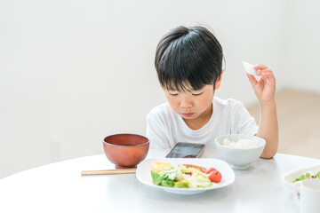 Digital meal while looking at mom's smartphone, child eating meal, toddler, boy
