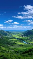 Panoramic Green Valley Landscape Under a Bright Blue Sky With Fluffy White Clouds And A Winding River Reflecting The Sky