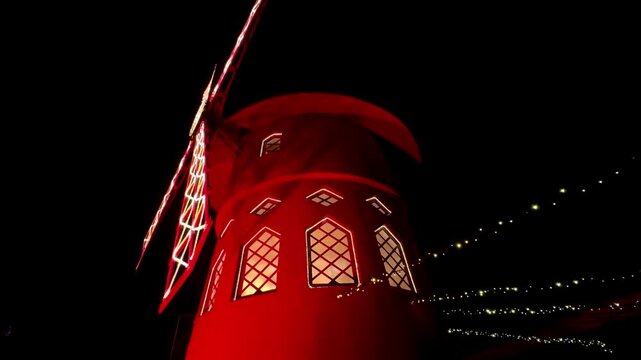 Romantic red windmill decoration part of circus installation at night Paris France 