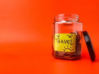 The image shows a glass jar with coins inside and a label that says Travel