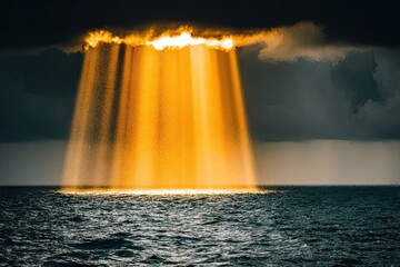 Sunbeams through dark clouds over ocean create a beam of light