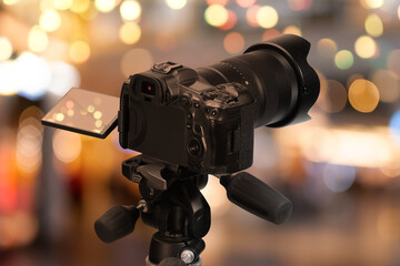 Professional camera against blurred background with bokeh lights