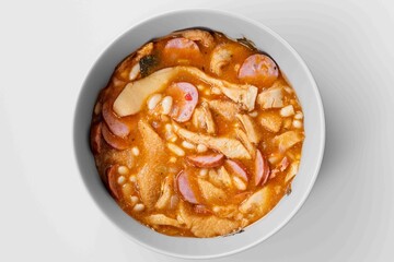 A classic Brazilian dish known as dobradinha, prepared with beef tripe, white beans, and tropical spices, served with traditional farofa made with toasted cassava flour.