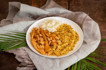 A classic Brazilian dish known as dobradinha, prepared with beef tripe, white beans, and tropical spices, served with traditional farofa made with toasted cassava flour.