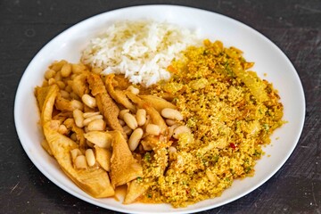 A classic Brazilian dish known as dobradinha, prepared with beef tripe, white beans, and tropical spices, served with traditional farofa made with toasted cassava flour.