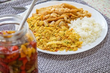 A classic Brazilian dish known as dobradinha, prepared with beef tripe, white beans, and tropical spices, served with traditional farofa made with toasted cassava flour.