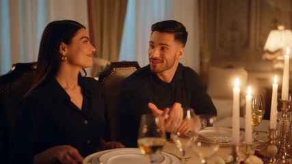 A couple enjoying a romantic dinner together at a table lit by candles, in a luxurious dining room. They are both smiling and appear to be in deep conversation Stock Video - Powered by Adobe