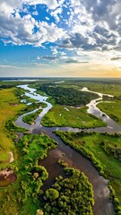Winding river cutting through green field