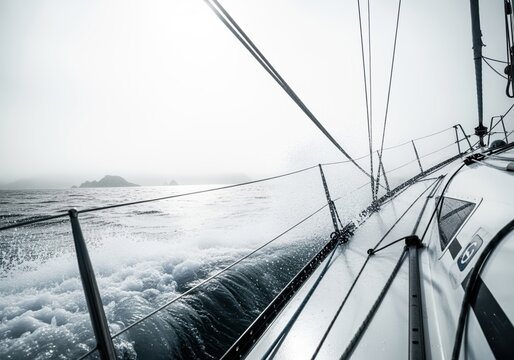 Low angle view from a racing sailboat deck cutting through powerful ocean waves