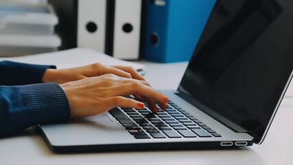 Focused view of hands typing on a laptop with documents and folders in background. Showcasing work, technology, and productivity. Stock Video - Powered by Adobe