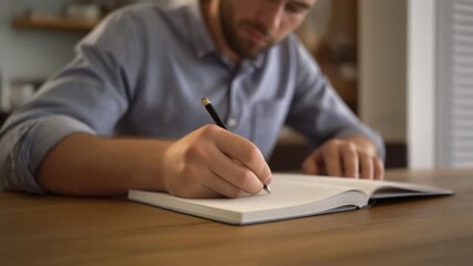 young man writing on a notebook - Powered by Adobe
