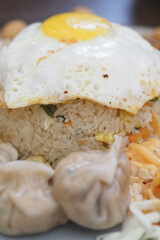 Fried rice topped with egg and dumplings from a local eatery