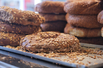 Fresh bagels topped with seeds in a bakery display