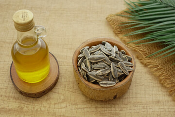 Sunflower seeds and oil on a wooden table in natural light