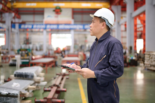 Engineer or technician writing on clipboard in the factory