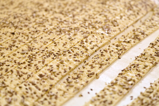 Cracker dough ribbons ready for processing on conveyor in a food production facility during the daytime