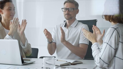 Professional team applauding, celebrating collaborative success and recognizing outstanding performance during corporate meeting, expressing shared workplace achievement. Business people concept