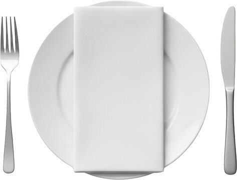 A white plate with a folded white cloth napkin sits between a silver fork and a silver knife isolate Silverware Table setting Dining Restaurant Formal