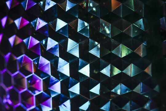 Mesmerizing holographic background with geometric pattern of cubes and triangles. vibrant, iridescent surface reflects light, creating futuristic visual