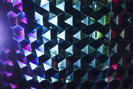 Mesmerizing abstract geometric crystal pattern background with futuristic purple and blue light reflection. fascinating view of vibrant optical illusion on faceted surface