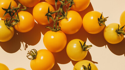 Freshly harvested yellow tomatoes on a light background