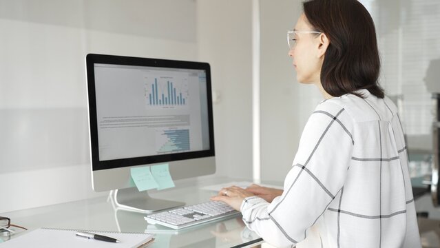 Woman analyst working on computer, analyzing business data with charts and graphs, marketing report on screen. Businesspeople concept - Powered by Adobe