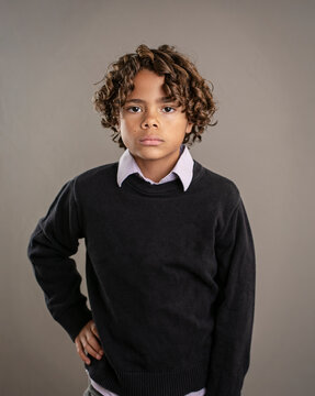 Cute fashion portrait of a diverse African American boy. Posed studio image of a handsome child wearing a collared shirt and a sweater