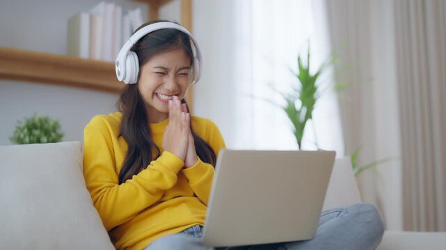 Funny euphoric young asian woman celebrating winning or getting ecommerce shopping offer on computer laptop. Excited happy girl winner looking at notebook celebrating success