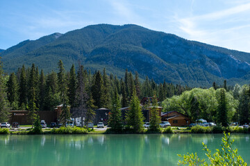 Obraz premium Scenic view of Banff, Canada with serene water and majestic mountains during a sunny day