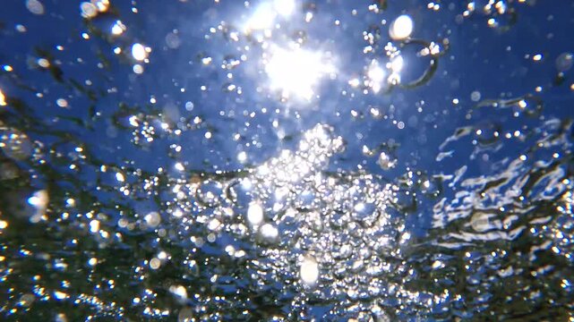 Underwater Bubbles with sunlight through water surface, natural slow motion underwater scene