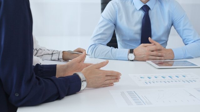 Business people reviewing financial metrics on digital screens, collaborating strategically while examining charts and graphs in office