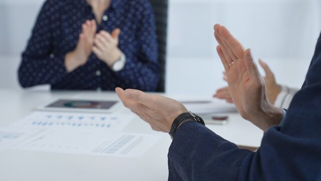 Business team applauding after successful presentation during a meeting in the office, celebrating achievement and good teamwork with positive attitude