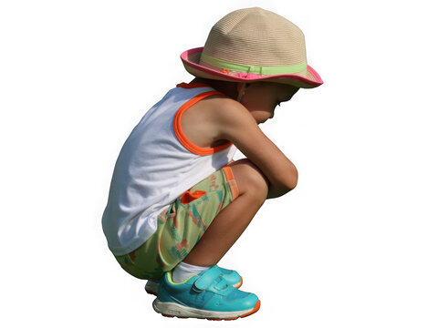 Young child in a hat and summer clothes crouching down isolated on transparent background