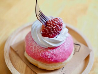 Donut topped with whippwd cream and fresh strawberries. They look so yummy and delicious.