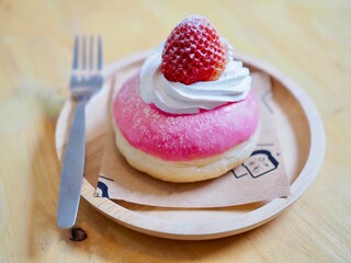 Donut topped with whippwd cream and fresh strawberries. They look so yummy and delicious.