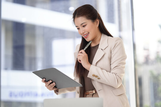 Asian business professional reviews work document plan strategy uses digital tablet pen in modern corporate office for company success growth productivity