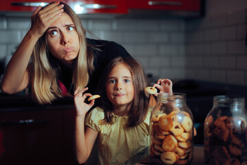 Mom Disapproving of her Kid Eating Cookies Before Lunch. Child disobeys her mother trying to overindulge on sweets 
