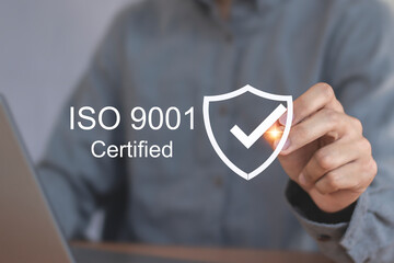 Quality control, certification and assurance concept according to ISO standards. Businessman using mobile phone with document and quality certification icons for ISO.