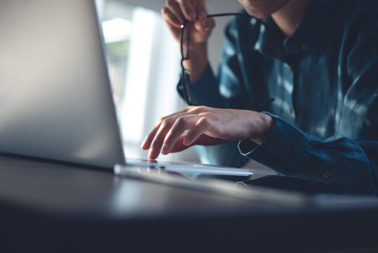 Close up, pensive business woman working on laptop computer and thinking of problem solution. Stressed entrepreneur working on laptop at office, searching the ideas, burnout at work