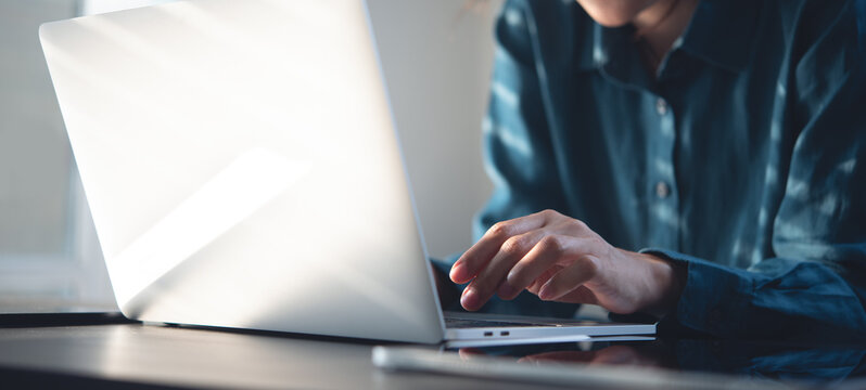 Young asian business woman busy working on laptop computer with digital tablet on office table. Student studying online class - Powered by Adobe