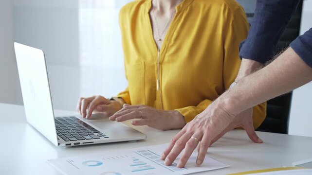 Professional team reviewing financial data on laptop, analyzing charts and strategizing corporate workflow, collaborating toward shared business objectives. Business people concept