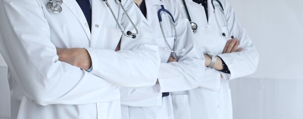 A group of doctors with folded arms demonstrates the professionalism of medicine, mutual support of clinics, and dedication to expert care in a hospital setting