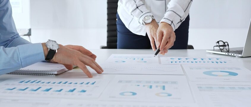 Business team analyzing financial charts during strategy meeting, professionals discussing data and performance metrics at workplace for decision making success - Powered by Adobe