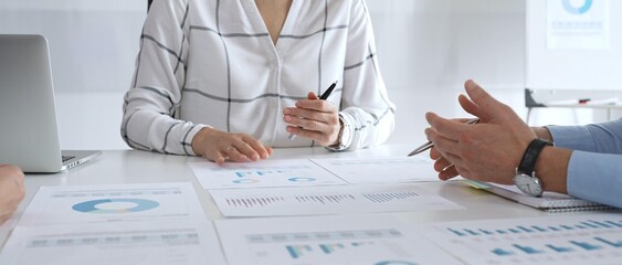 A business meeting with colleagues in a modern office where financial schedules, work planning, and reports are discussed in a team effort