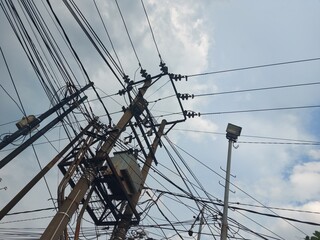 This image captures an intricate network of electric power lines, transformers, and utility poles. The shot highlights the complexity of modern power distribution systems, with overhead wires.