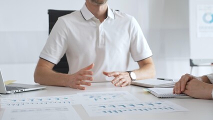 Business team reviewing financial charts, collaborating intently around conference table in contemporary workspace, sharing insights during strategic planning session in office