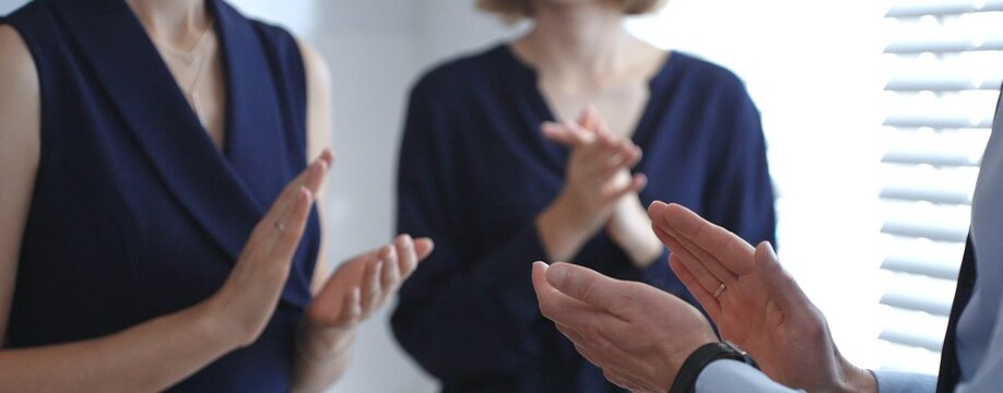 Business people clapping hands, showing support and appreciation for achievements, success, and accomplishment during a company meeting or presentation in modern office
