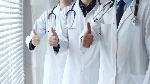 Medical team showing thumbs up gestures, symbolizing healthcare success, collaboration, good results, excellent medical service, and professional doctor approval